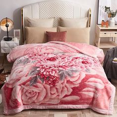 a bed with pink flowers on the comforter and matching pillow cases in a bedroom