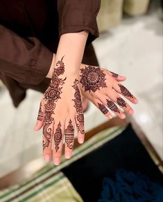 two hands with henna tattoos on them