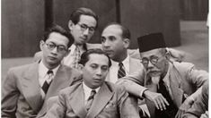 black and white photograph of men in suits sitting next to each other