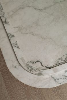 a white marble table top sitting on top of a hard wood floor