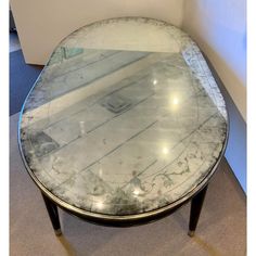 a round glass table sitting on top of a carpeted floor next to a white wall