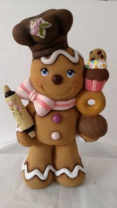 a ceramic figurine holding a doughnut and cupcake