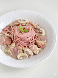 a white plate topped with pasta and mushrooms