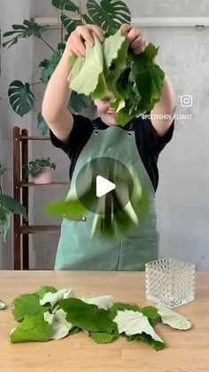 a person holding up some leaves on top of a table