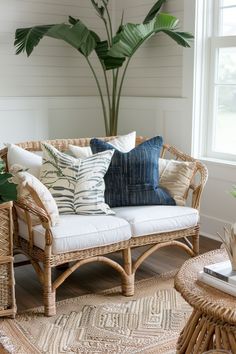 a living room with wicker furniture and large plant in the corner, along with white walls