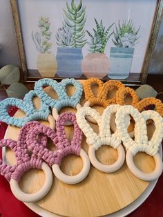 six crocheted wooden rings sitting on top of a table next to a potted plant