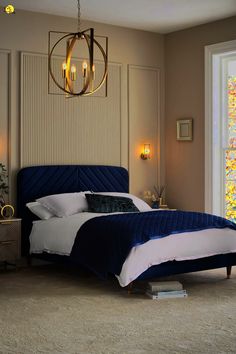 a bedroom with a bed, nightstand and chandelier hanging from the ceiling in front of a window