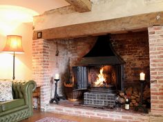 a living room filled with furniture and a fire place in the middle of it's fireplace