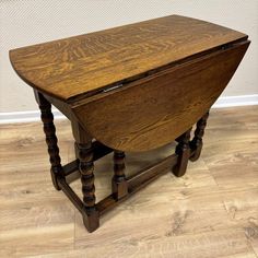 an old wooden desk with turned legs on the bottom and one drawer at the top