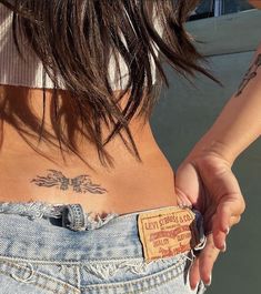 the back of a woman's stomach with tattoos on her left side and chest