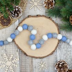 a wooden table with pine cones and ornaments on it, including snowflakes