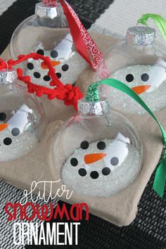 three snowman ornaments are sitting on a tray