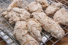 a bunch of cookies that are on a cooling rack with some powdered sugar on top