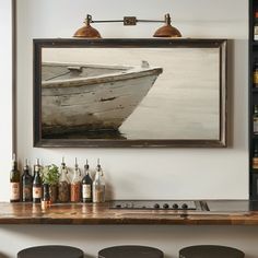 a painting hanging on the wall above a bar with stools and bottles in front of it