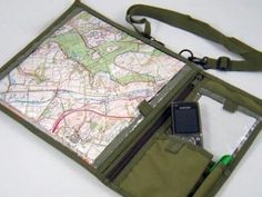 a map, cell phone and wallet sitting on top of a white table with a green strap