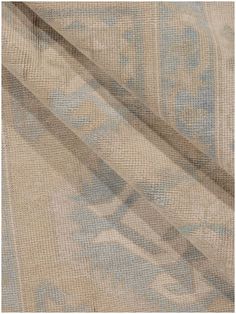 an image of a beige and blue fabric with intricate designs on it's edges