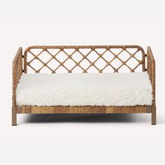 a wicker daybed with white fur on it