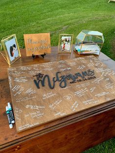 a wooden table topped with pictures and writing on top of green grass covered in dirt