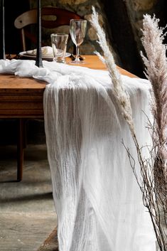 an image of a table setting with flowers and candles on the table cloth, next to wine glasses