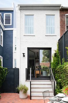 an outdoor dining area in front of a house