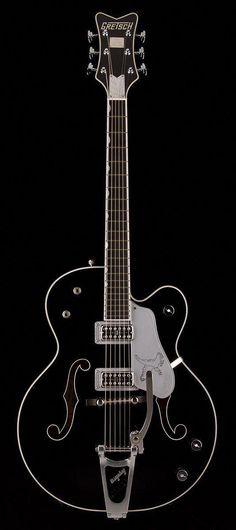 an electric guitar sitting on top of a black surface with strings attached to the neck