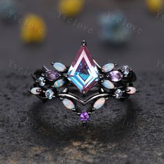 a ring with an amethorate and multicolored stones in it on top of a table