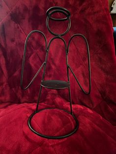 a metal sculpture sitting on top of a red couch