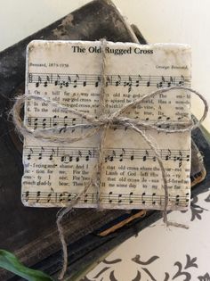 an old rugged cross with sheet music notes tied to it, sitting on top of a book