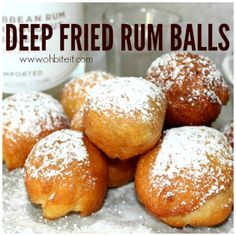 a pile of deep fried rum balls sitting on top of a white tablecloth with powdered sugar