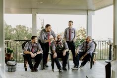 a group of men sitting next to each other on top of a porch