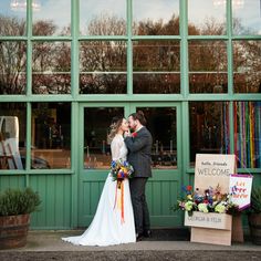 a bride and groom kissing in front of a store