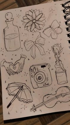 an open notebook with various items drawn on it, including a camera and umbrellas