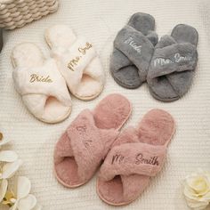 four pairs of slippers with personalized names are laid out on a white blanket