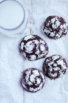 three chocolate crinkle cookies next to a glass of milk