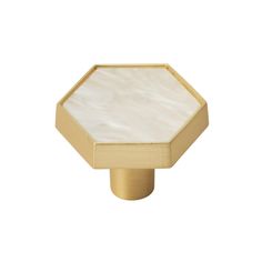 an octagonal brass knob with white mother of pearl inlay on the top and bottom