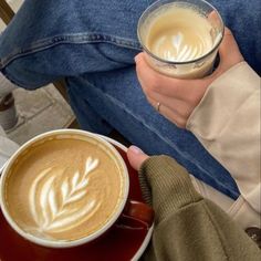 a person holding a cup of coffee in their hand