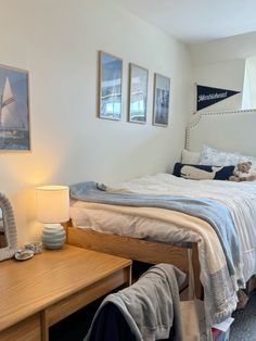 a bed room with a neatly made bed and pictures on the wall