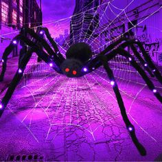 a large spider with glowing eyes on it's back in front of some buildings