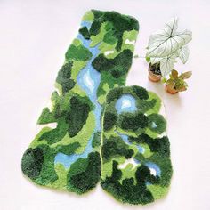 a pair of oven mitts made out of green mossy plants next to a potted plant