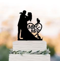 a wedding cake topper that says mr and mrs on it with a silhouette of a bride and groom