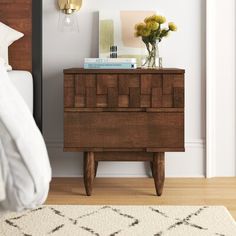 a bedroom with a bed, nightstand and flowers on top of the night stand in front of the bed