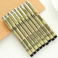 six pens sitting next to each other on top of a table