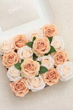 an open box filled with pink and white roses