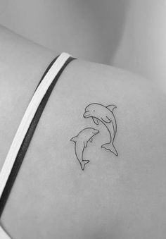 two dolphins on the back of a woman's shoulder