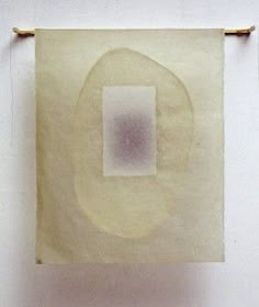 a piece of paper hanging on a wall next to a white object with an oval in the middle