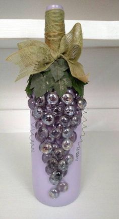 a purple bottle with grapes in it and a bow on the top is sitting on a table