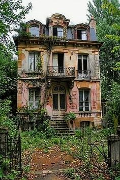 an old house in the woods with lots of windows and balconies on it