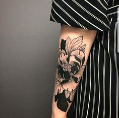 a woman with a flower tattoo on her left arm and the other arm is black and white