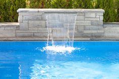 a blue swimming pool with water spouting from it