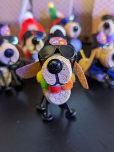 a group of toy dogs wearing sunglasses and hats on top of a black table next to each other